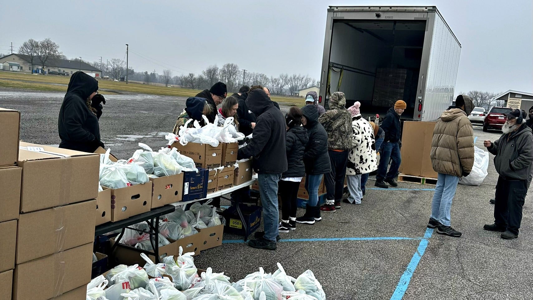 Residents receive groceries and fresh food through a community food distribution program supported by local volunteers.