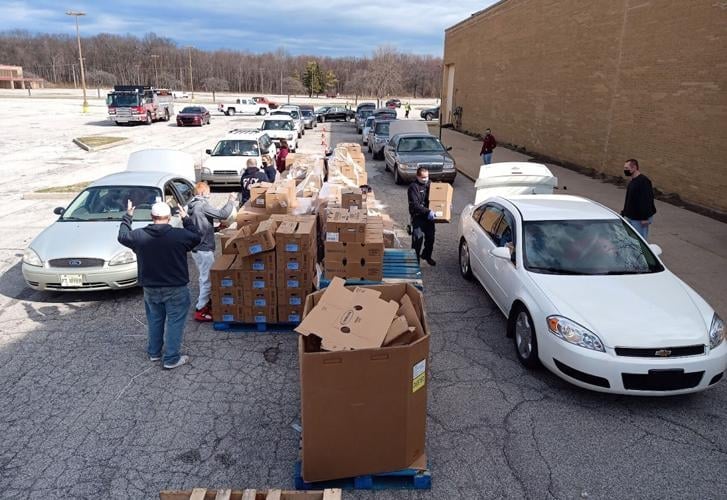 Volunteers organize and distribute food to local families through a large-scale community food assistance program.