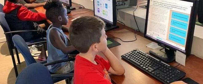 Students use computers during an educational technology program that supports digital literacy and academic success.