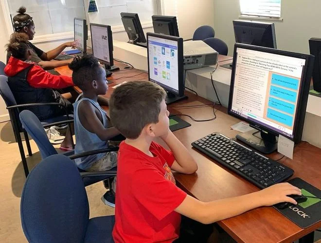 Students use computers during an educational technology program that supports digital literacy and academic success.