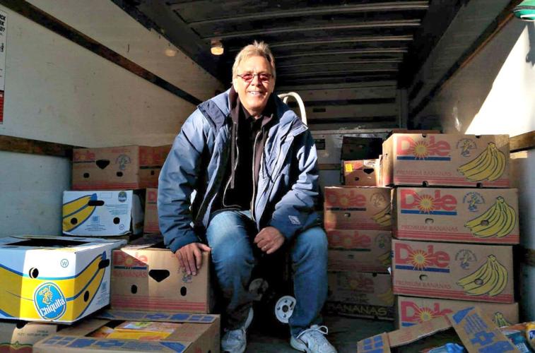 A community leader prepares donated food and fresh produce for distribution through local hunger relief programs.